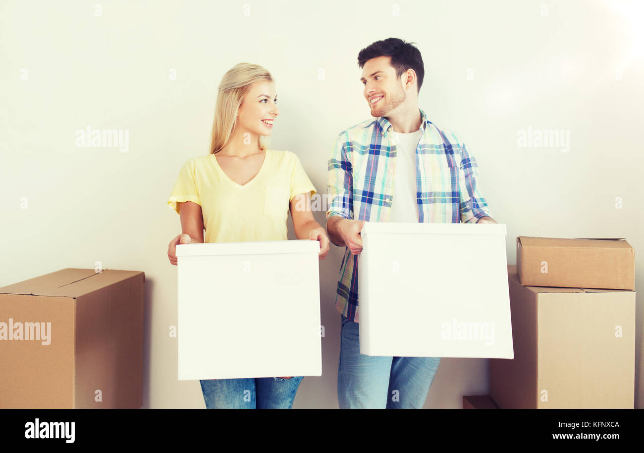 smiling couple with big boxes moving to new home Stock Photo - Alamy