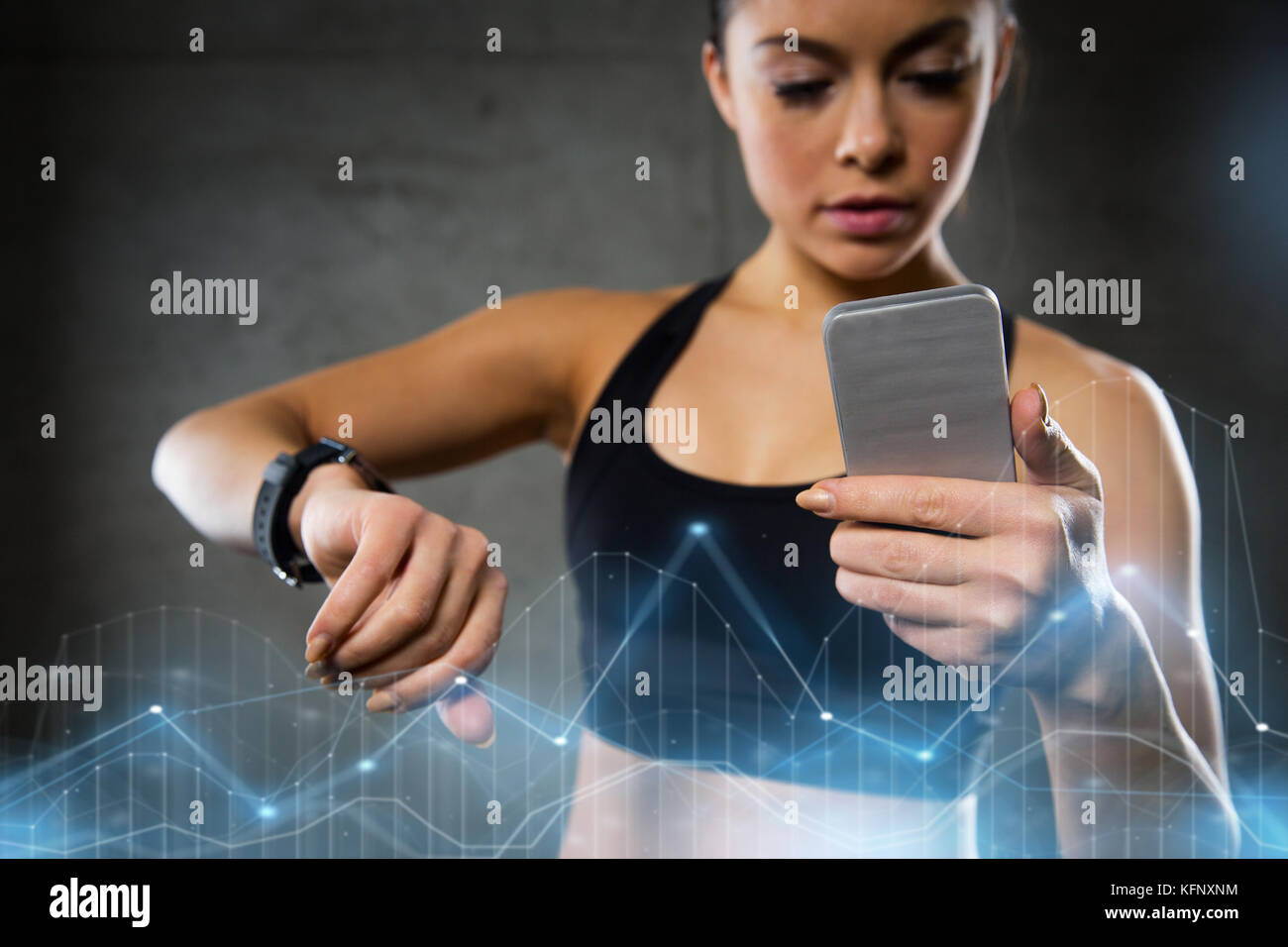 woman with heartrate watch and smartphone in gym Stock Photo Alamy