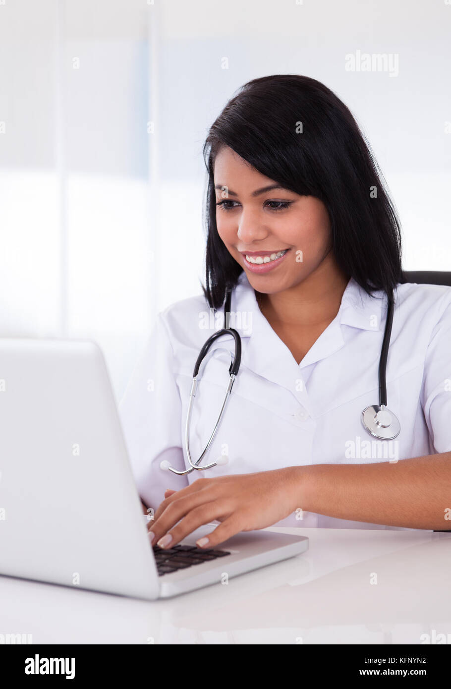 Pretty Young Confident Doctor Using Laptop In Clinic Stock Photo