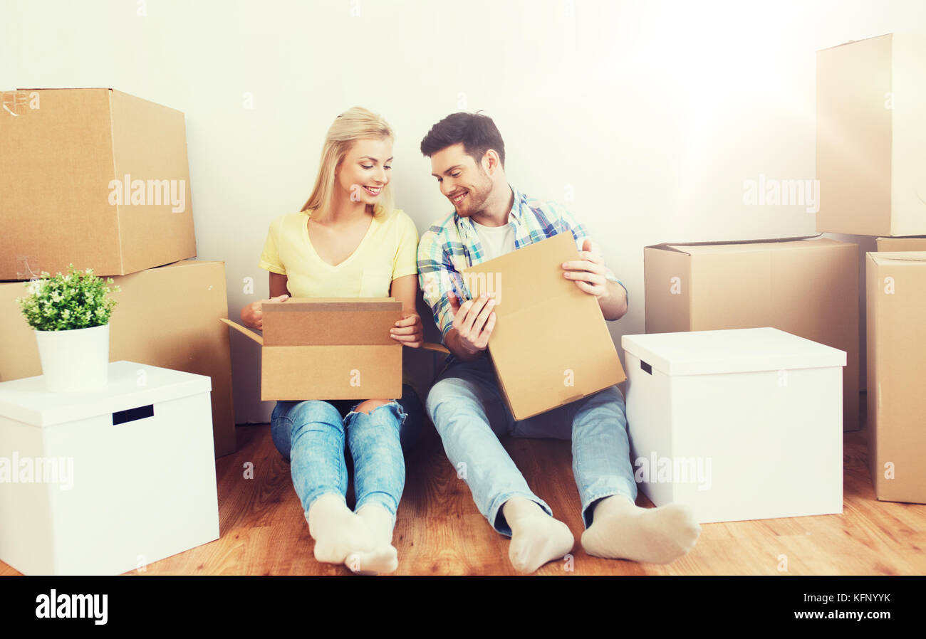 smiling couple with many boxes moving to new home Stock Photo - Alamy