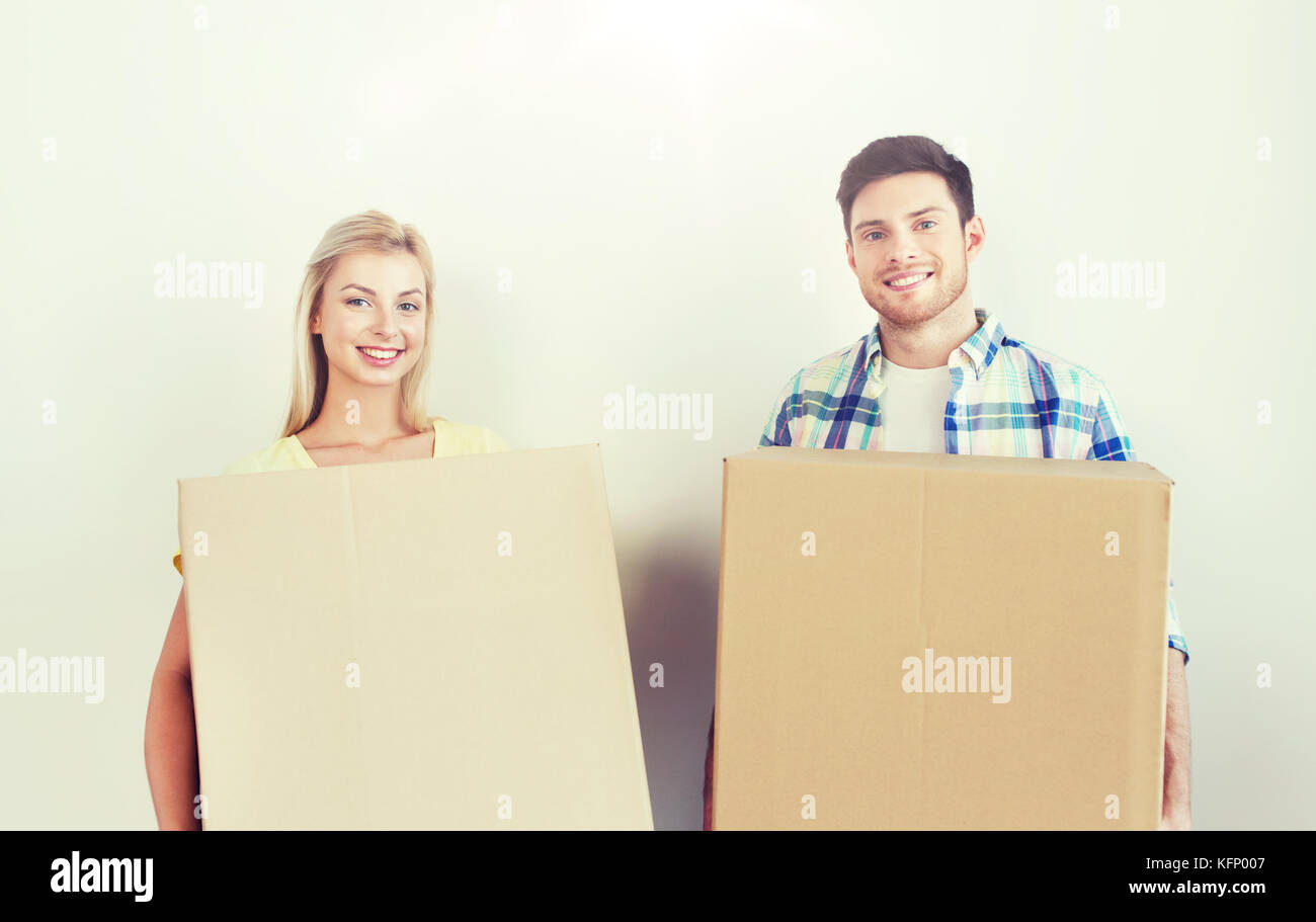 smiling couple with big boxes moving to new home Stock Photo - Alamy