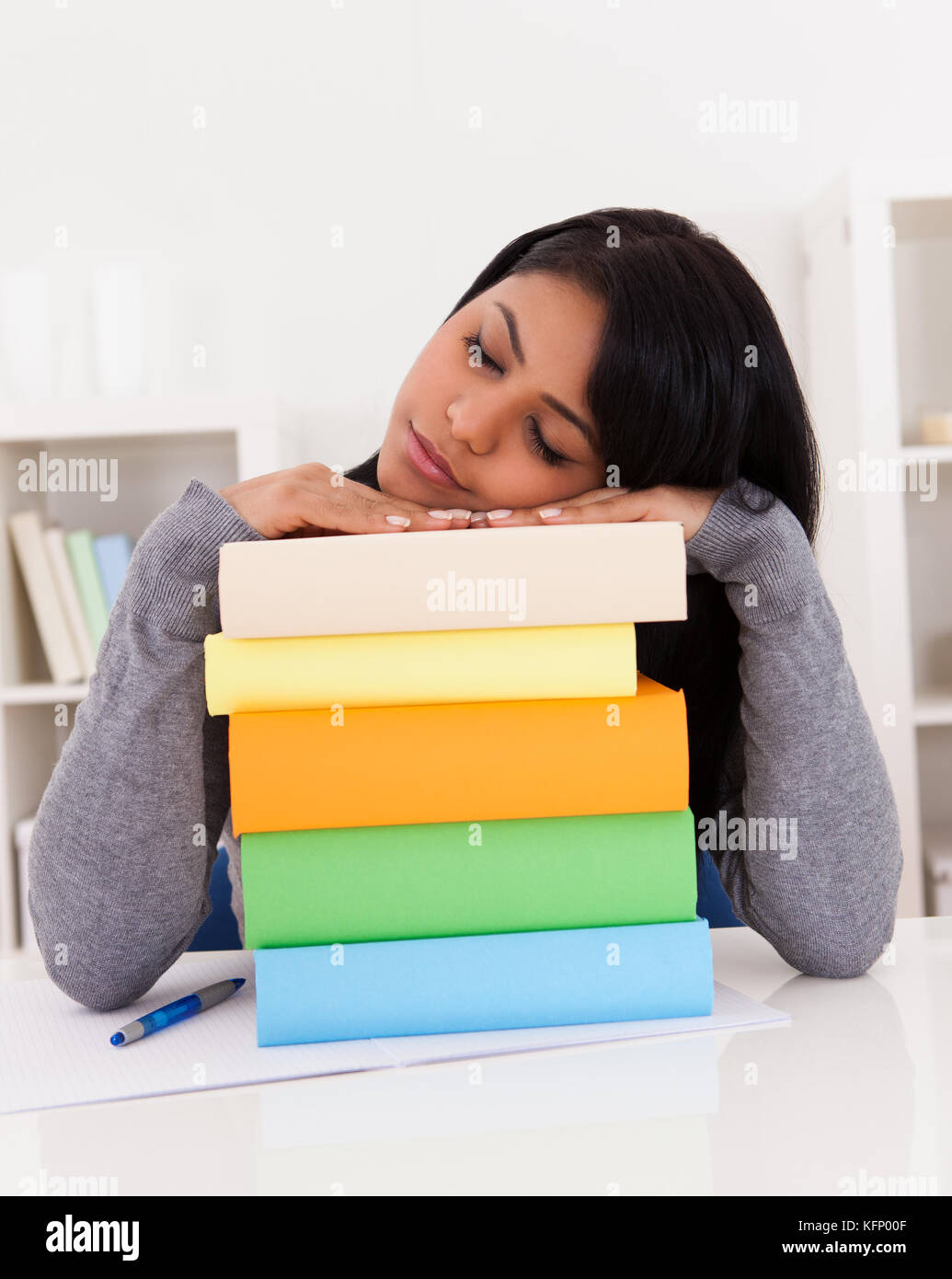 Portrait Of Young Woman Sleeping While Studying At Home Stock Photo