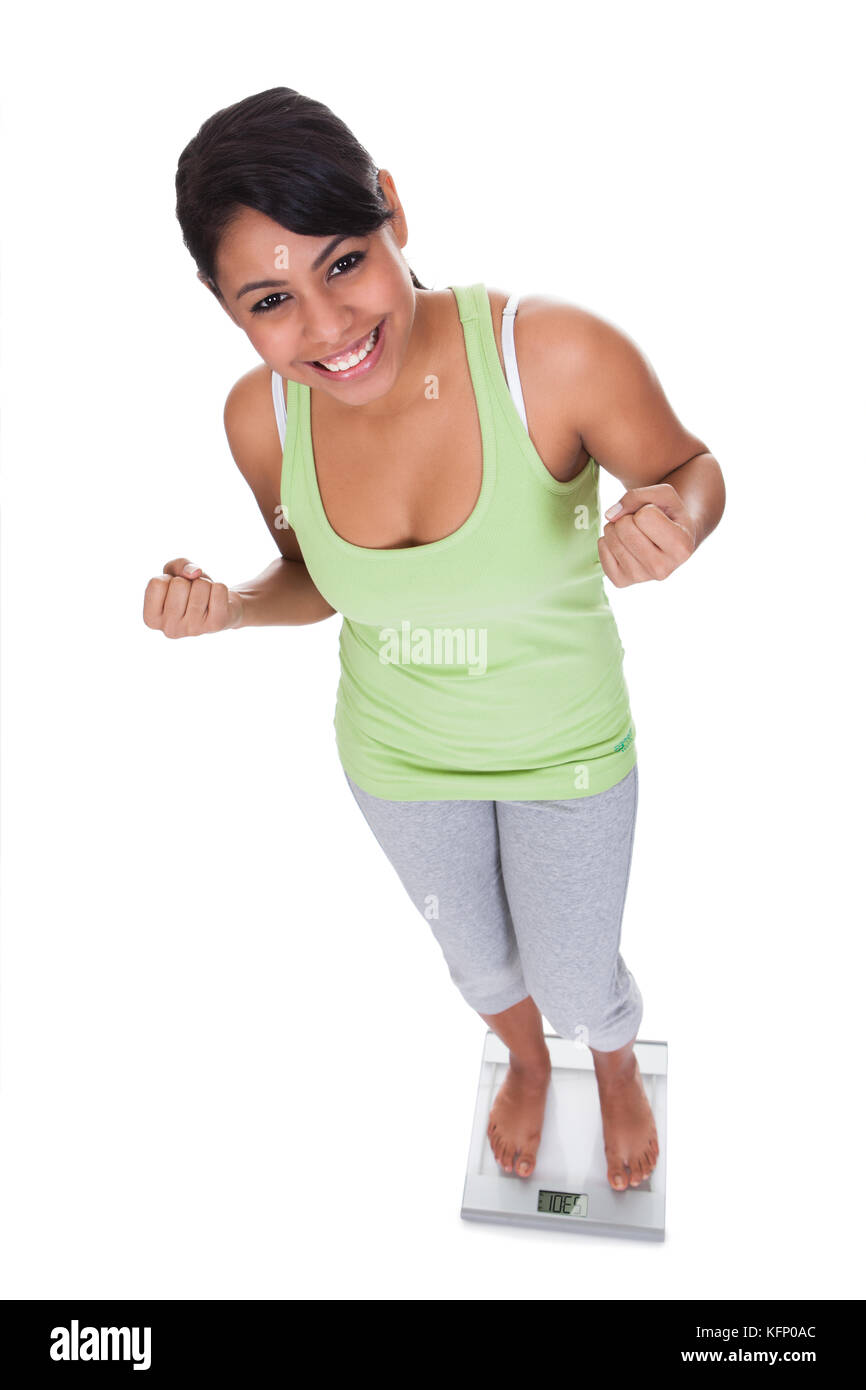 https://c8.alamy.com/comp/KFP0AC/happy-woman-standing-on-weighing-scale-over-white-background-KFP0AC.jpg