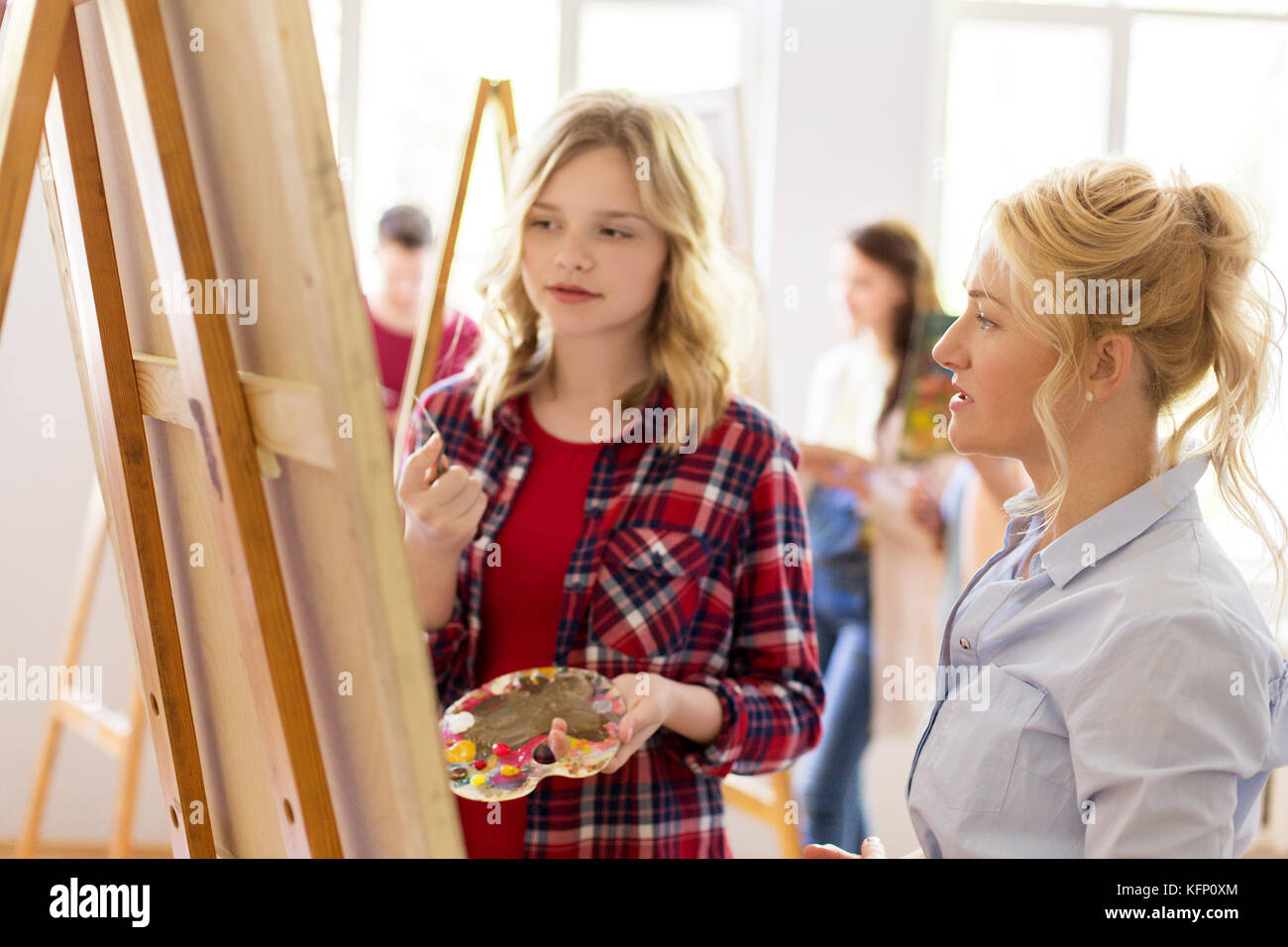 artists discussing painting on easel at art school Stock Photo