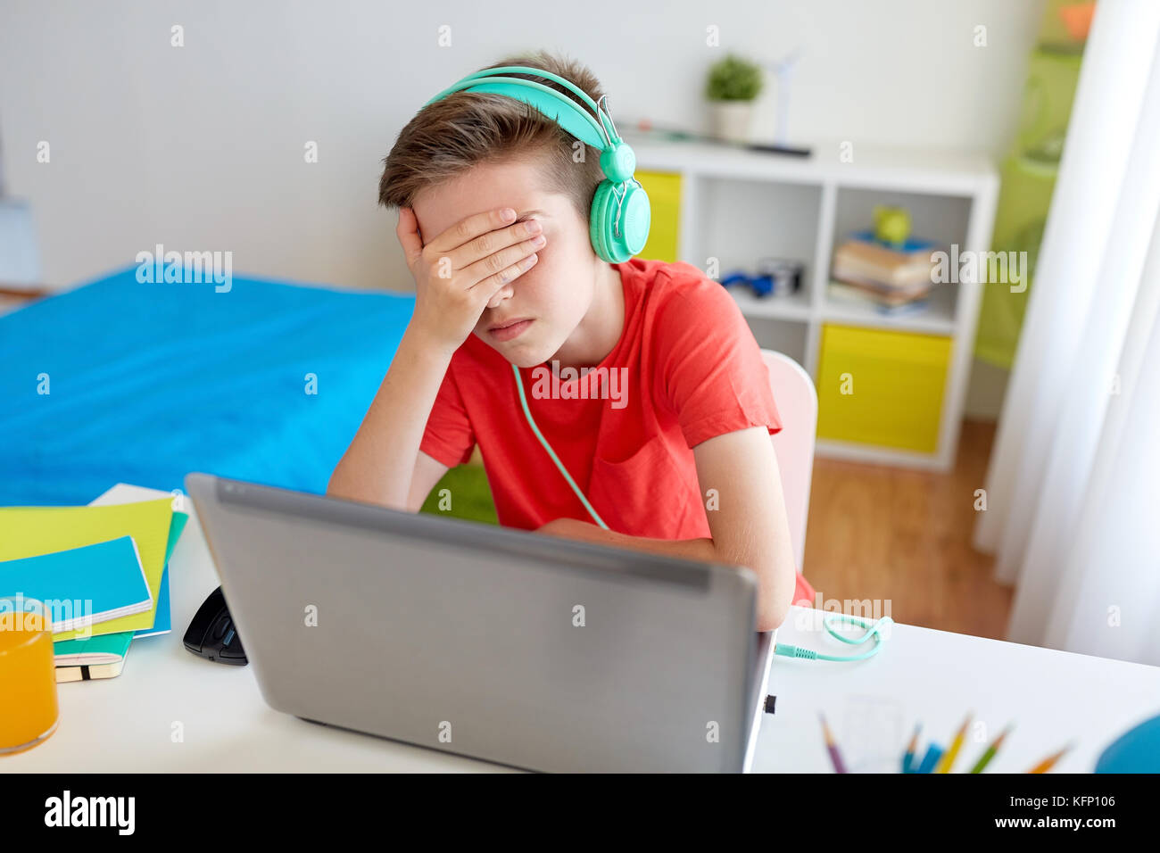 boy in headphones playing video game on laptop Stock Photo