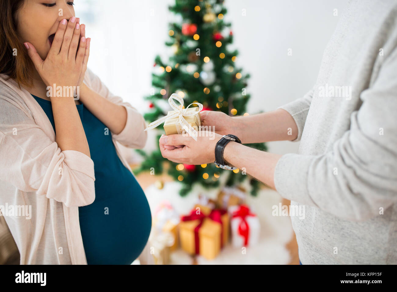 husband giving christmas present to pregnant wife Stock Photo - Alamy