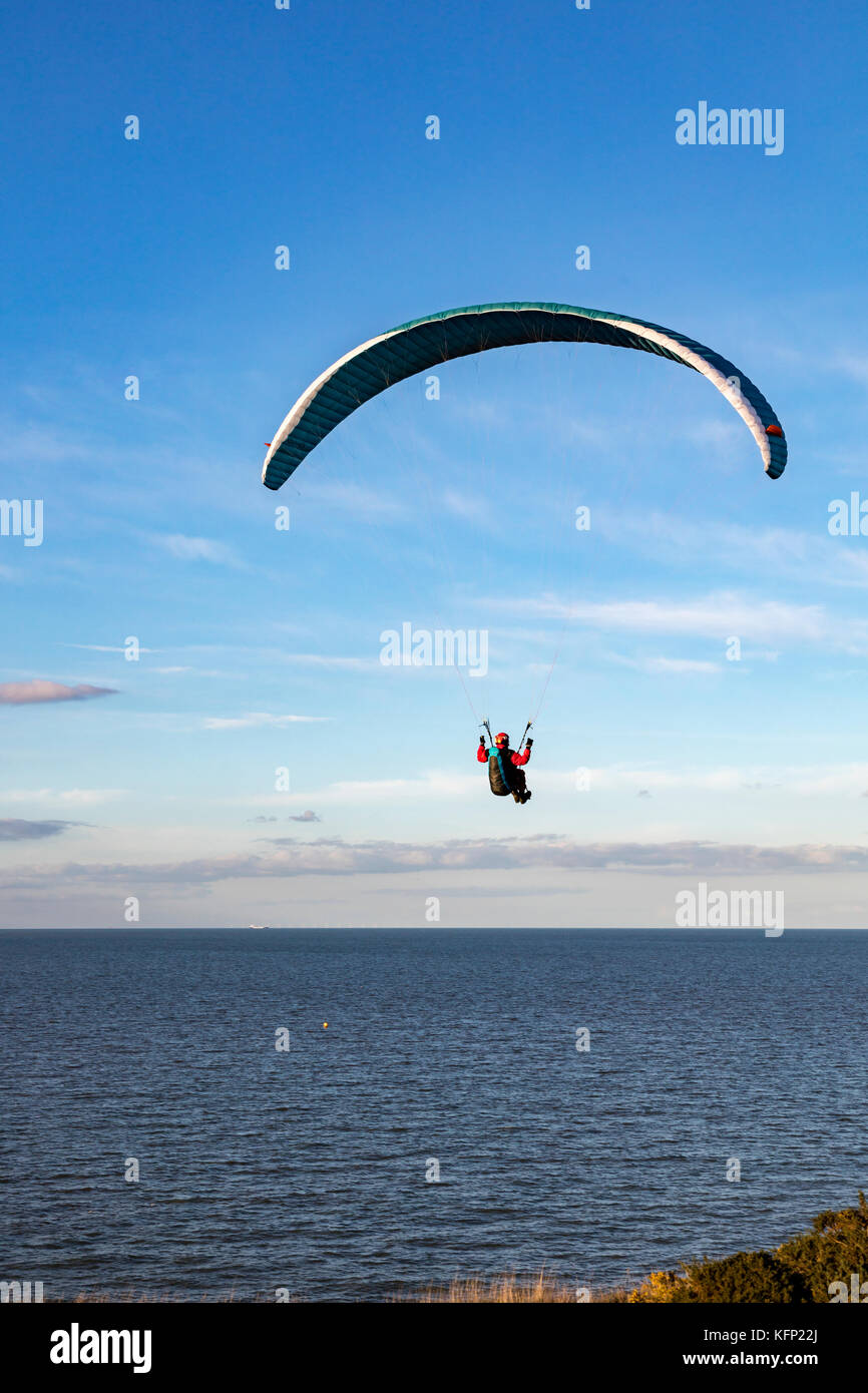 Para gliders take advantage of the onshore breeze giving them lift above the cliffs at Bishopstone, Herne Bay, Kent, UK. Stock Photo
