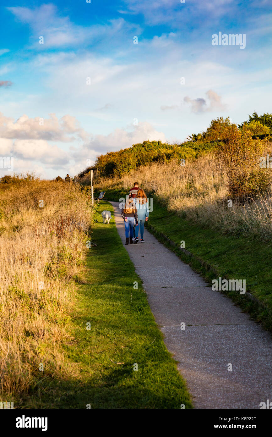 A young family and their dog make theire way up the cliffs at