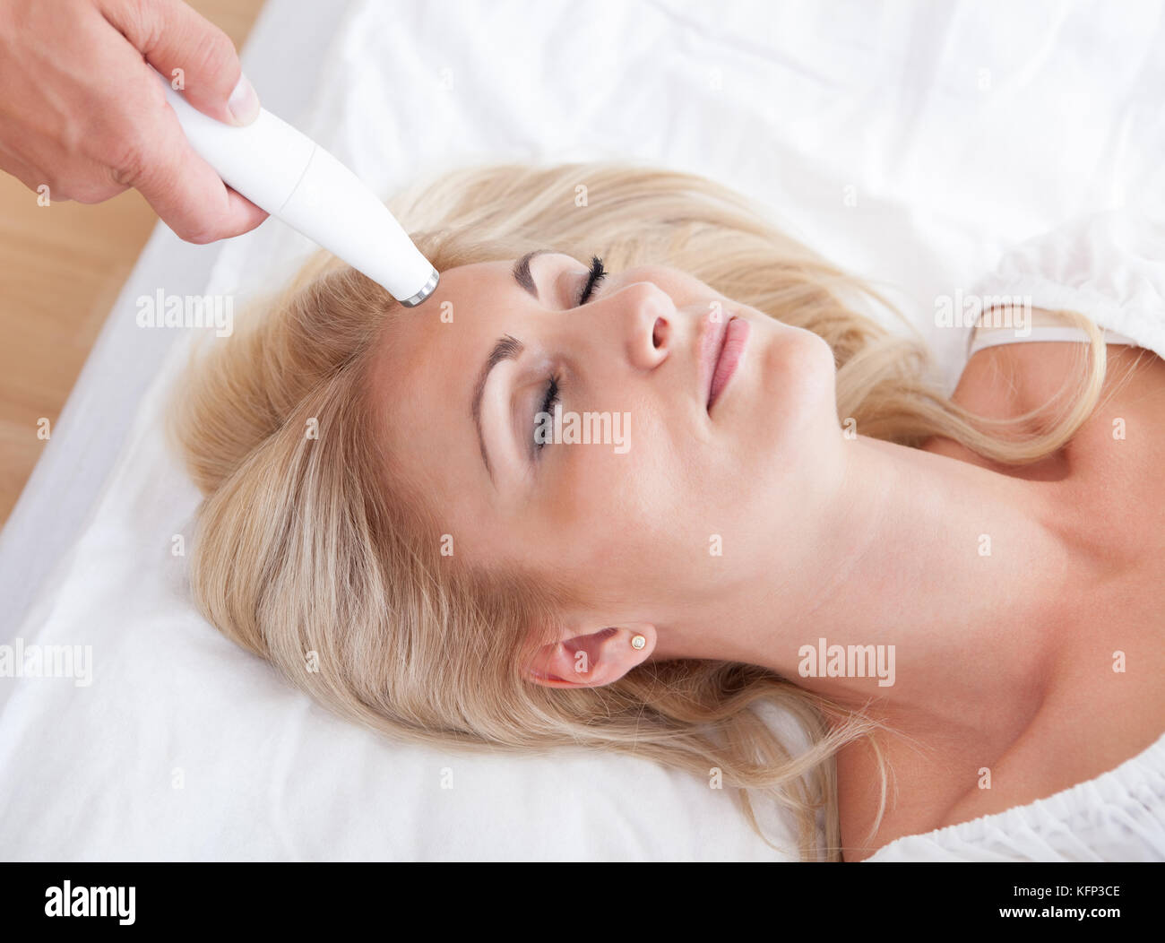 Profile View Of Happy Young Woman During Cosmetic Treatment, Indoors Stock Photo