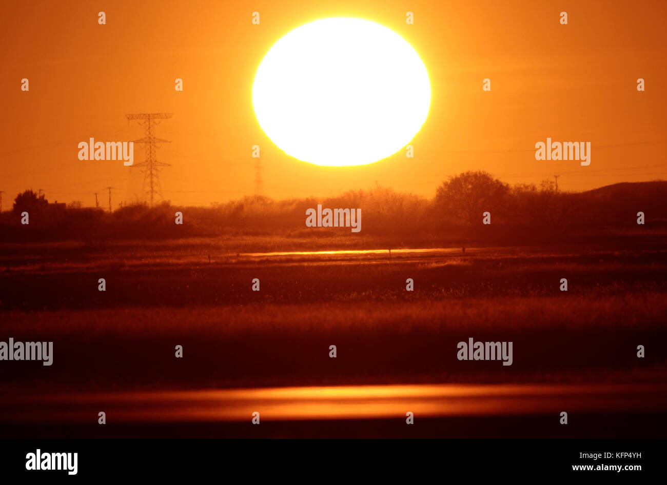 Sun seen at sunset on the horizon to the west of the capital of Sonora, located in the desert northwest of Mexico.    The Sun is a star of spectral type G2 which lies in the center of the solar system and is the largest source of electromagnetic radiation of this planetary system. Earth and other bodies orbit around the sun.    Distance to Earth: 149,600,000 km  Radio: 696,000 km  Surface temperature: 5,778 K  Mass: kg 1,989E30  Absolute size: 4.83  Magnitude: -26.74 Stock Photo