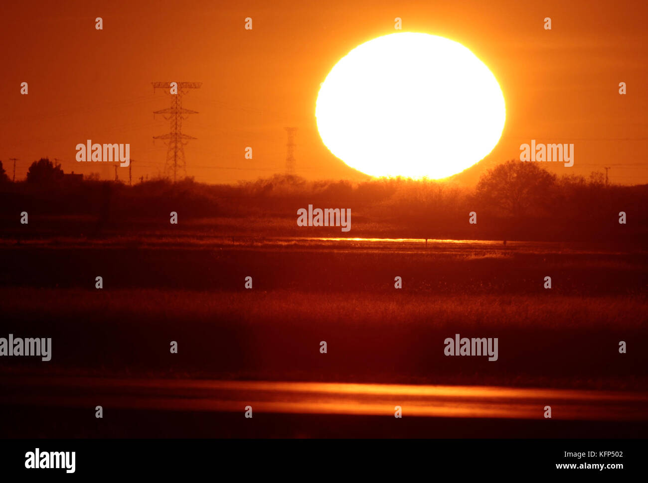 Sun seen at sunset on the horizon to the west of the capital of Sonora, located in the desert northwest of Mexico.    The Sun is a star of spectral type G2 which lies in the center of the solar system and is the largest source of electromagnetic radiation of this planetary system. Earth and other bodies orbit around the sun.    Distance to Earth: 149,600,000 km  Radio: 696,000 km  Surface temperature: 5,778 K  Mass: kg 1,989E30  Absolute size: 4.83  Magnitude: -26.74 Stock Photo