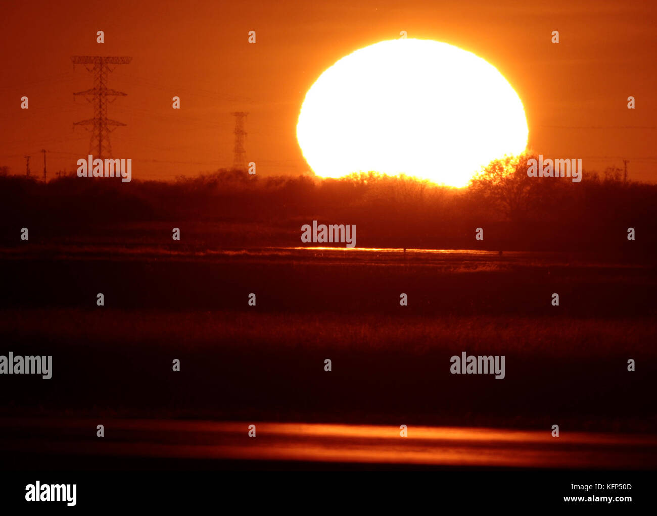 Sun seen at sunset on the horizon to the west of the capital of Sonora, located in the desert northwest of Mexico.    The Sun is a star of spectral type G2 which lies in the center of the solar system and is the largest source of electromagnetic radiation of this planetary system. Earth and other bodies orbit around the sun.    Distance to Earth: 149,600,000 km  Radio: 696,000 km  Surface temperature: 5,778 K  Mass: kg 1,989E30  Absolute size: 4.83  Magnitude: -26.74 Stock Photo