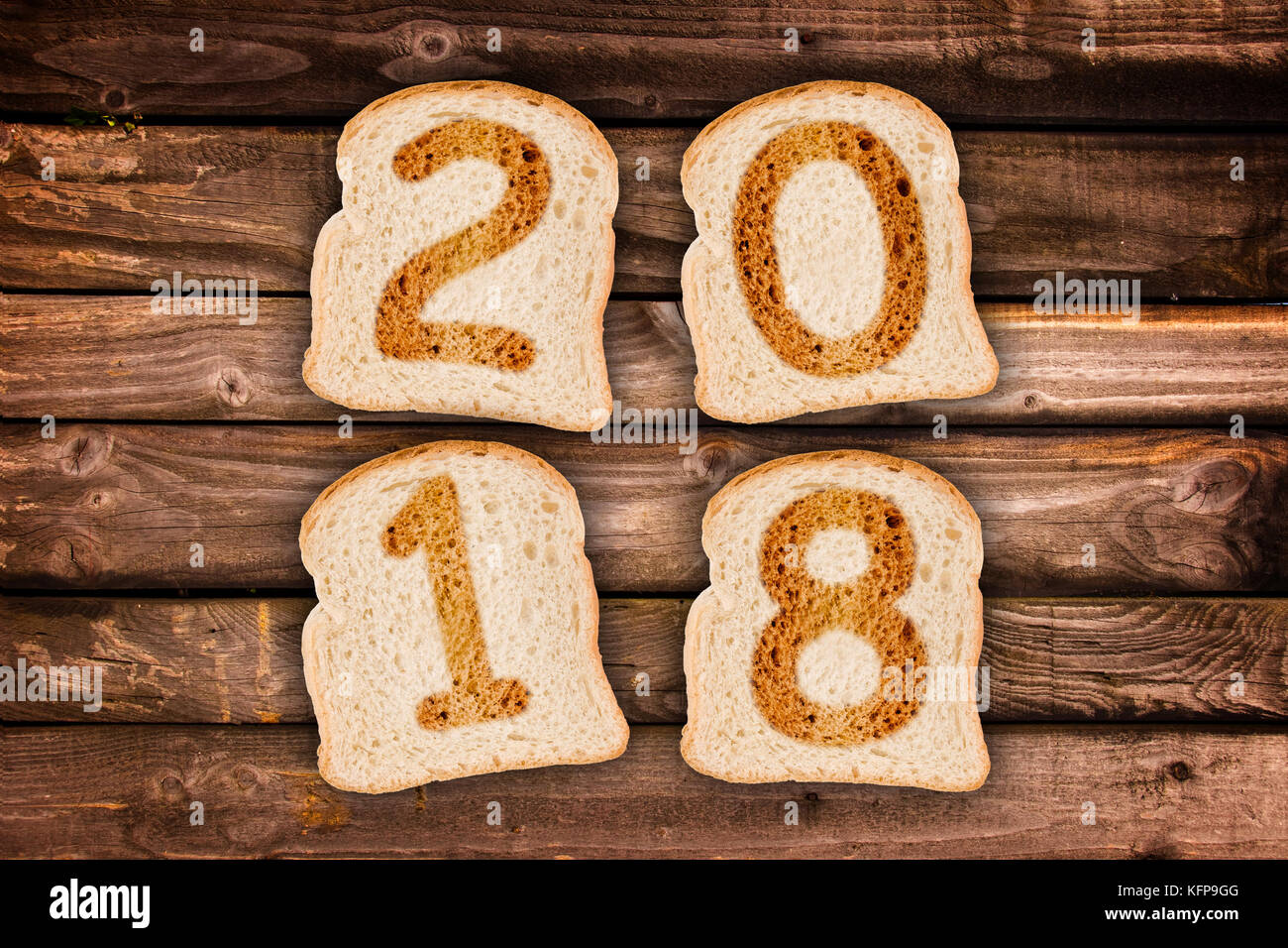 2018 greeting card toasted slices of bread on wooden planks background Stock Photo