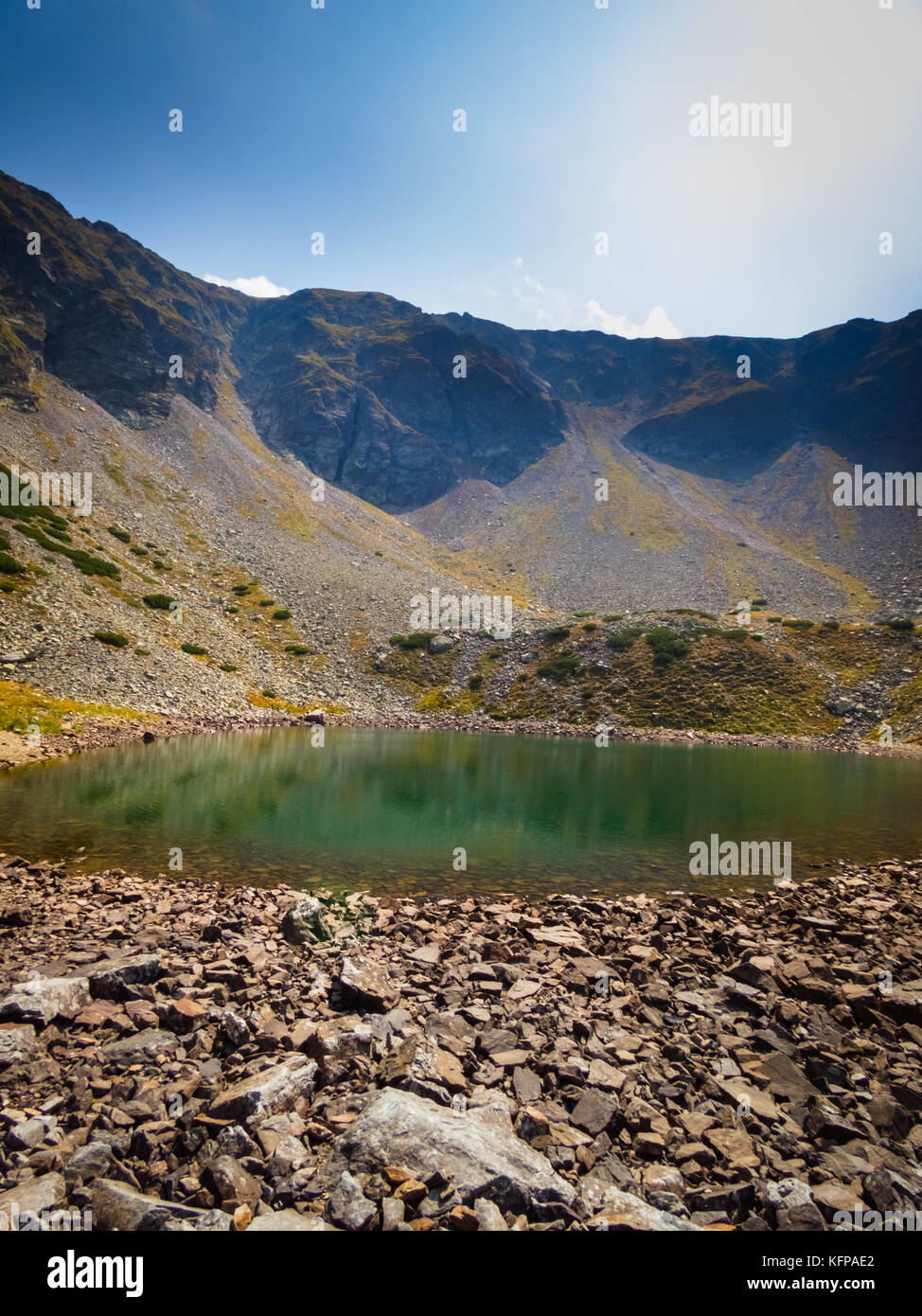 Rocks at the shore of a glacial lake high in the wilderness of the Carpathian Mountains. Stock Photo