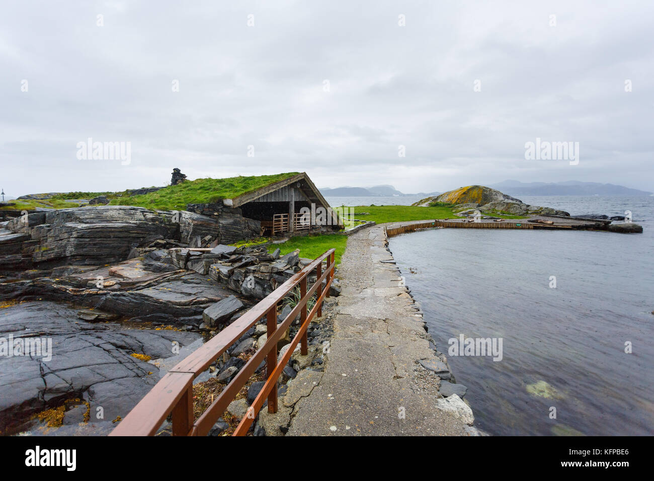Abandoned wooden house on the stony shore of Norwegian island in rainy weather Stock Photo