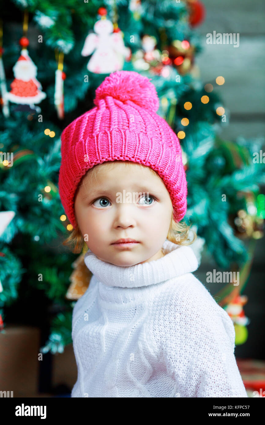 Cute Little Girl Wearing A Pink Hat At Home With Christmas Tree Stock Photo Alamy