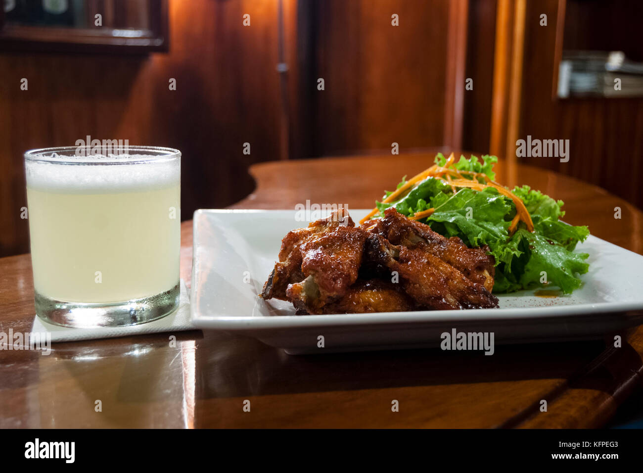 Pisco sour and chicken wings Stock Photo