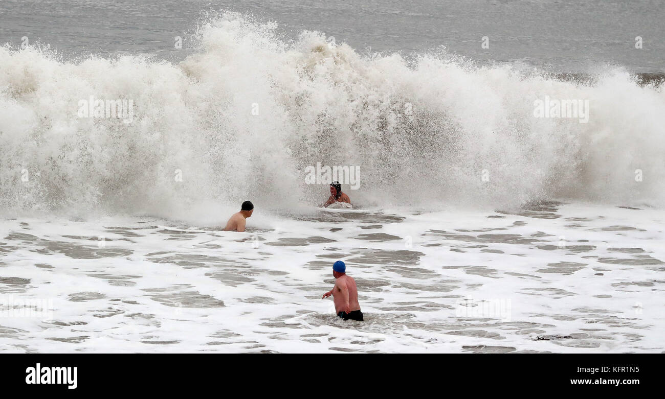 Brave swimmers from the Panama Swimming Club in Whitley Bay, Tyne and Wear, enter the North Sea for a dip as giant waves lash the shore. Picture date: Tuesday October 31, 2017. Photo credit should read: Owen Humphreys/PA Wire Stock Photo