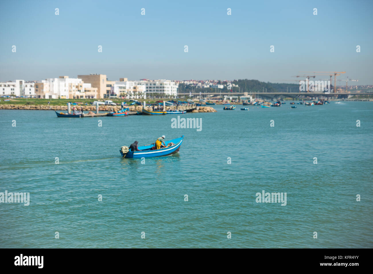 A boat crossing bouregreg river, view from la marina, sale bouregreg project in the background Stock Photo