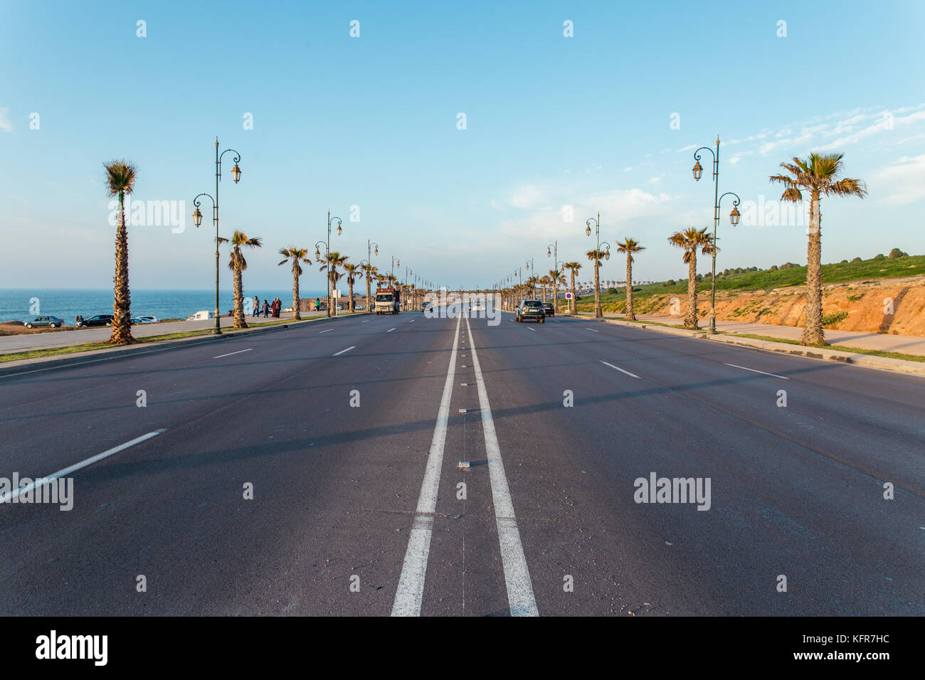 Empty road between a row of palm trees on a sunny summer day, Rabat, Morocco Stock Photo