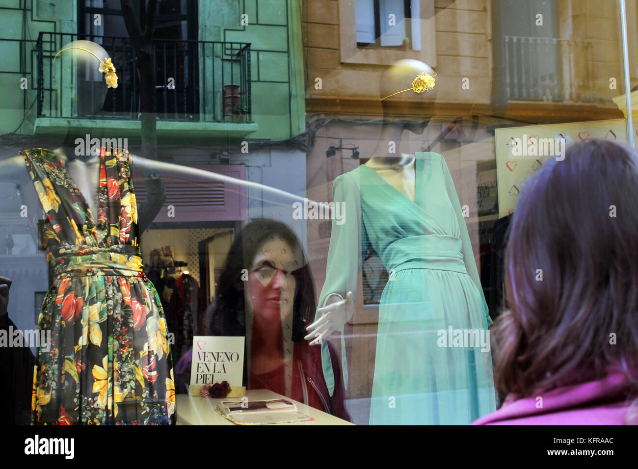 Image of a woman looking shop window shopping of designer clothes shop