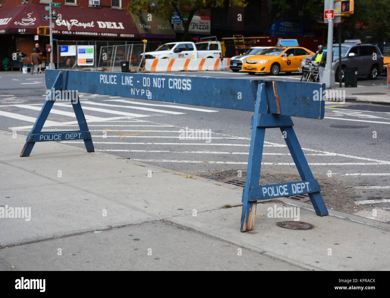 NEW YORK - OCTOBER 23, 2017: Police line do not cross wooden barrier stands on a sidewalk. Traffic waits beyond at the corner of West 54th Street and  Stock Photo