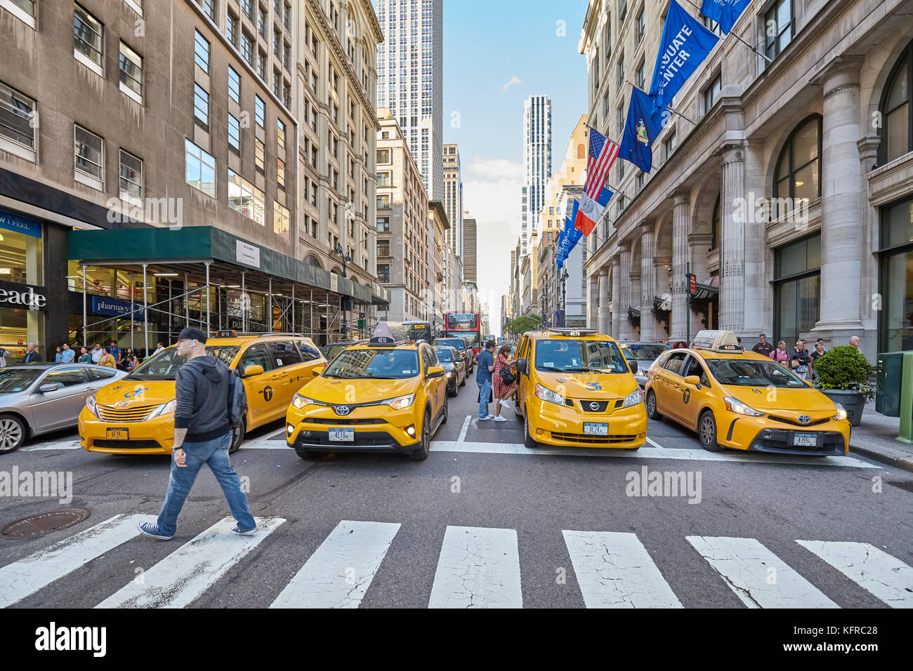 New York, USA - May 26, 2017: Yellow cabs waiting in front of a pedestrian crossing during rush hour. Stock Photo