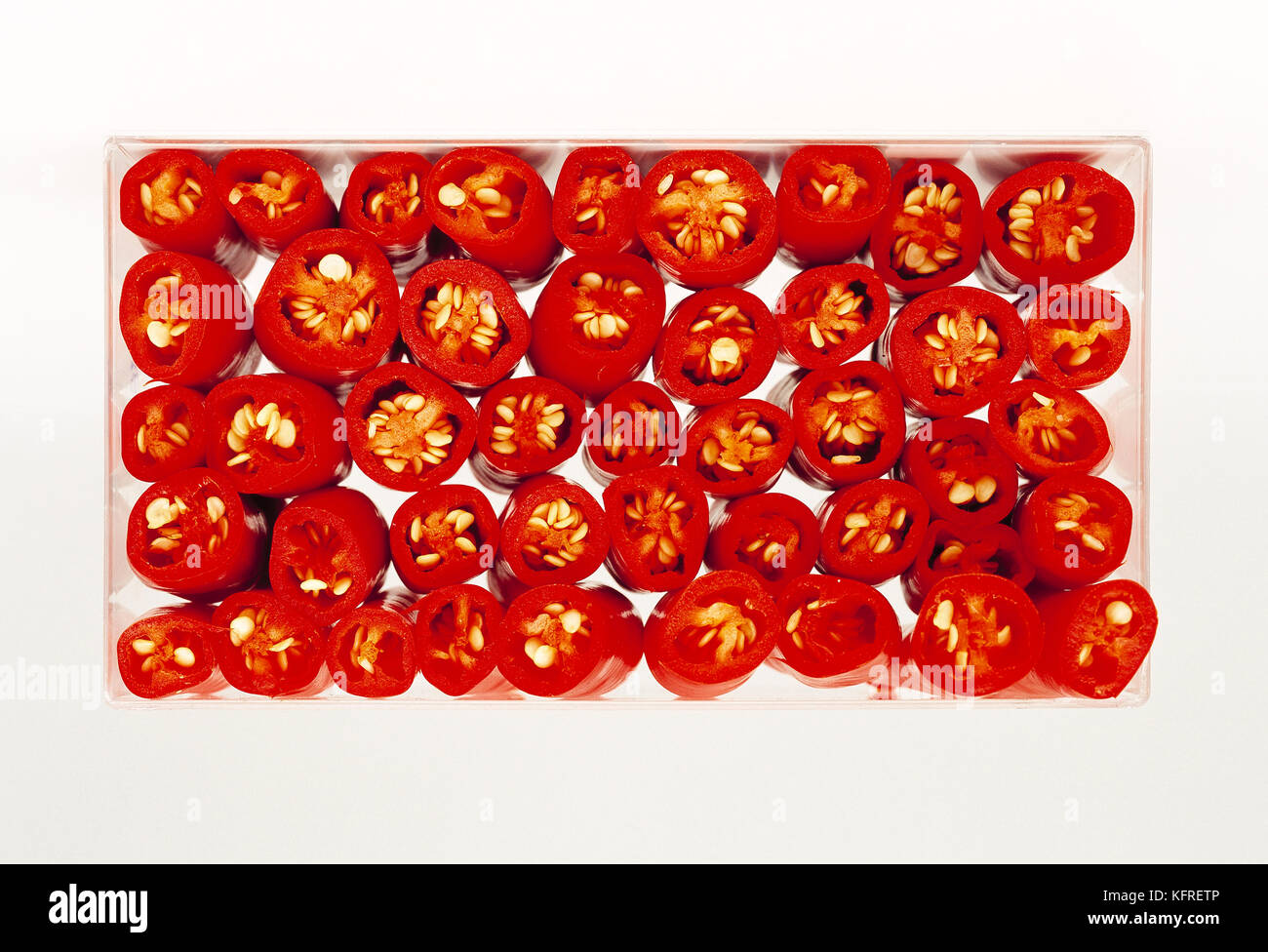 Still life. Food. Close up of sliced red chilli peppers in ceramic dish. Stock Photo