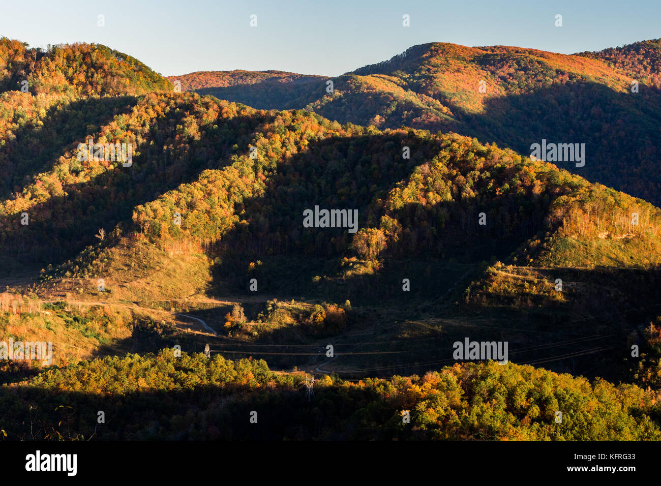 The sun is low in the sky on a mountain during the autumn months. Stock Photo
