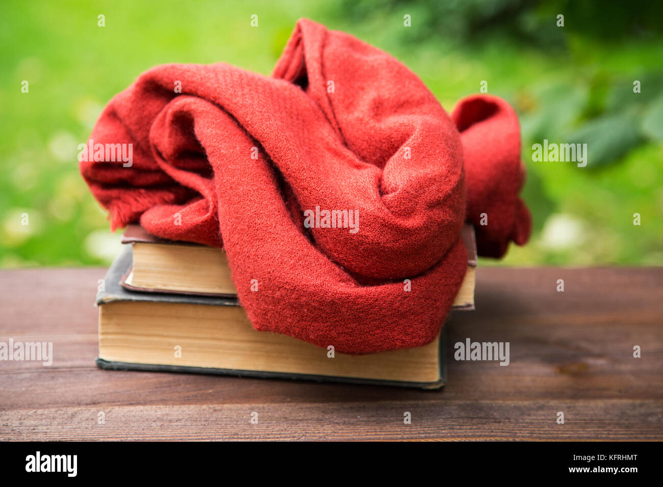female scarf and books on the table on the grass background Stock Photo