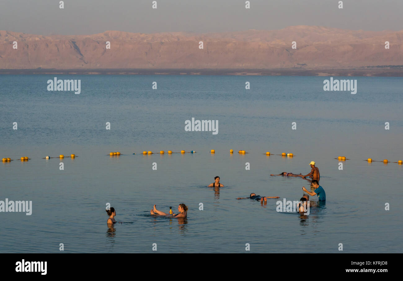 Early morning, Holiday Inn Dead Sea beach resort, with people floating in salty water and taking photos, with view to West Bank, Jordan, Middle East Stock Photo