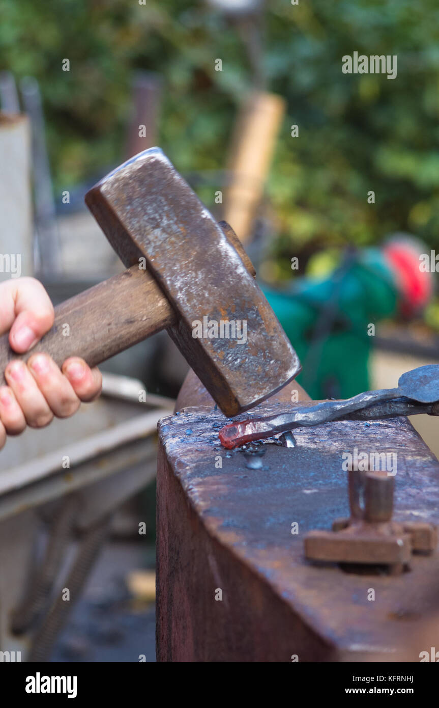 blacksmith and apprentice working on the anvil, close-up Stock Photo