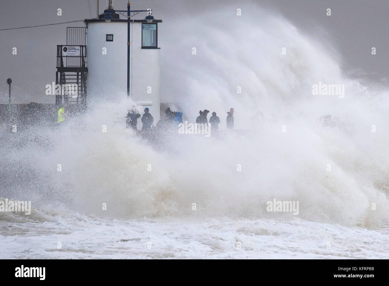 Waves crash against the harbour wall during Storm Brian at Porthcawl, South Wales. The Met Office have issued a yellow weather warning for wind and ha Stock Photo