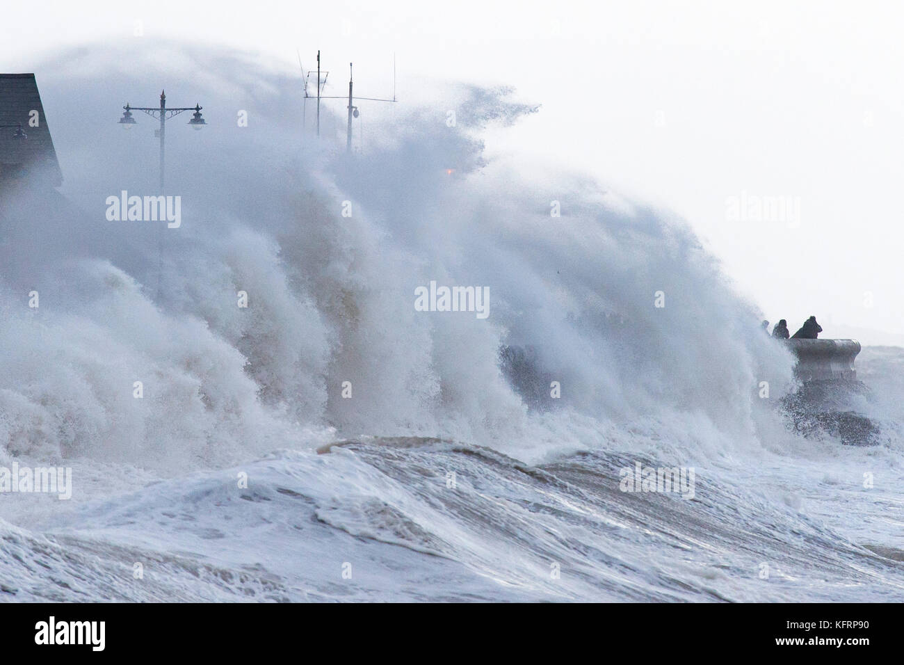 Waves crash against the harbour wall during Storm Brian at Porthcawl, South Wales. The Met Office have issued a yellow weather warning for wind and ha Stock Photo