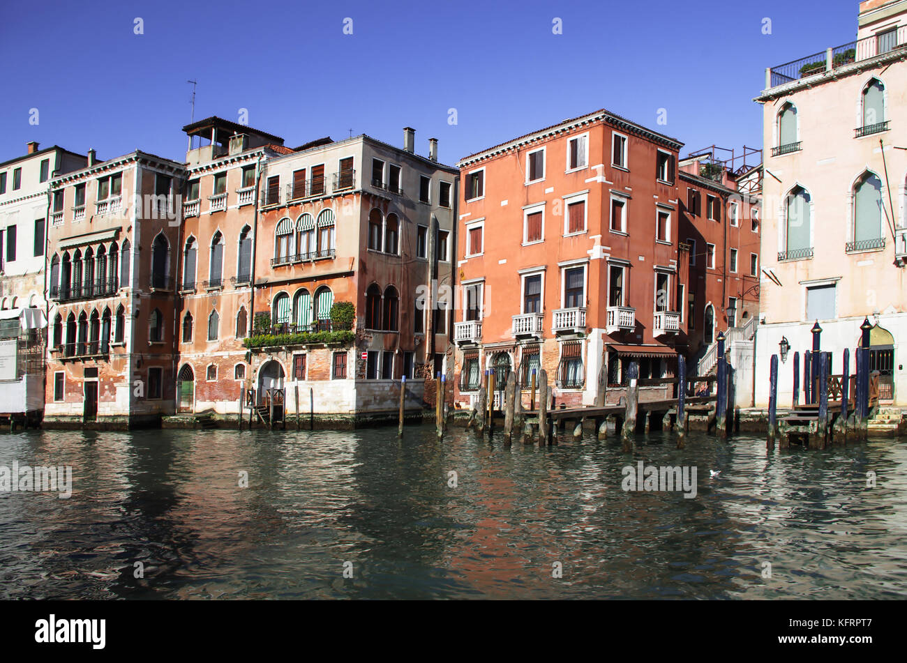 elegant mansions overlooking the large canal, cheer for centuries with their vibrant and bright colors, the Venetian atmosphere Stock Photo