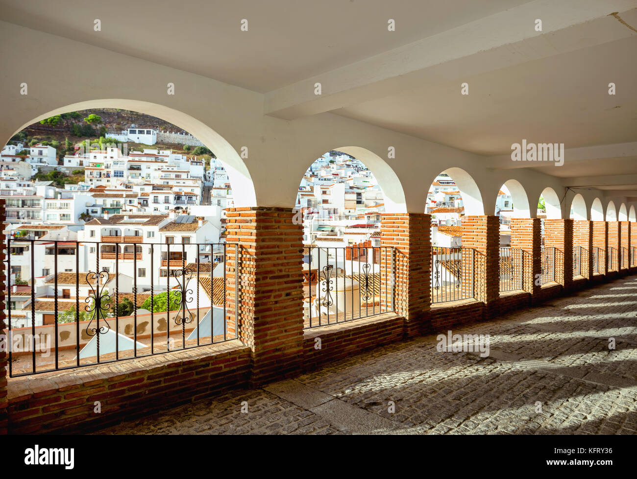 Path through gallery with arches windows and view of white village Mijas. Andalusia, Spain Stock Photo