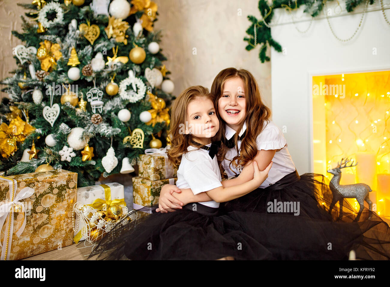 Charming girls posing together in Christmas studio Stock Photo - Alamy
