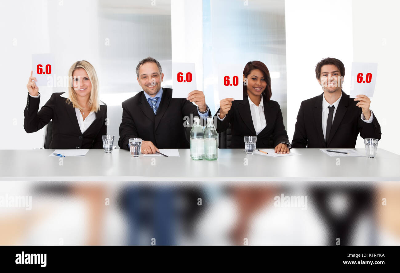 Group of panel judges holding perfect score signs Stock Photo