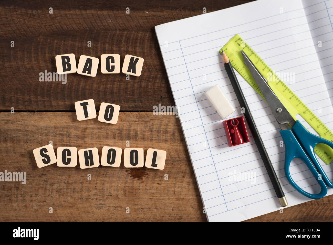 back to school concept - book,pen,ruler,eraser and pencil sharpener on a wooden table Stock Photo