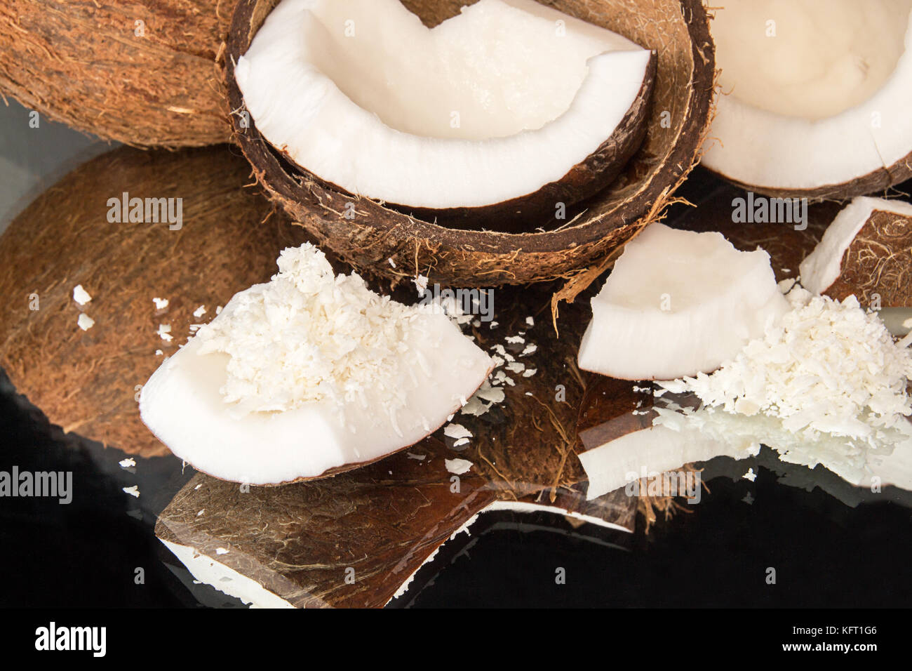 Halfs of coconut, pieces of coconat, coconut flakes on black background
