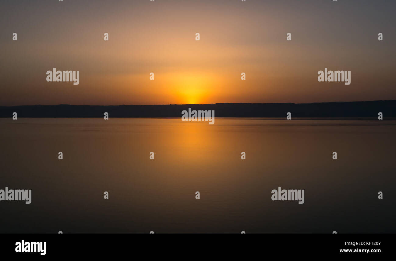 Minimalist orange sunset over the Dead Sea from Jordan shoreline, looking towards the West Bank, Middle East Stock Photo