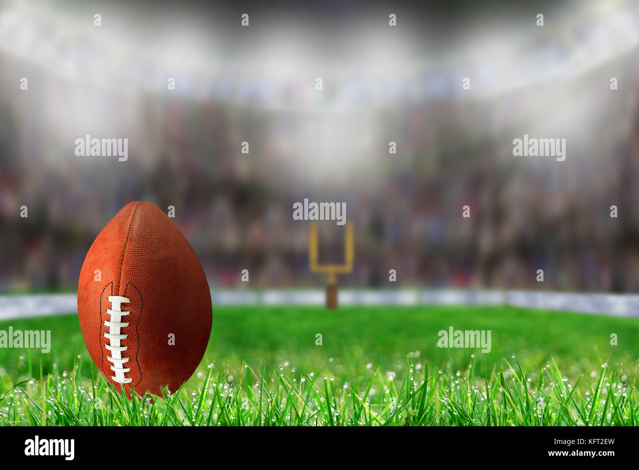 Low angle view of football on field grass and deliberate shallow depth of field on brightly lit stadium background with copy space. Ready for kick off Stock Photo