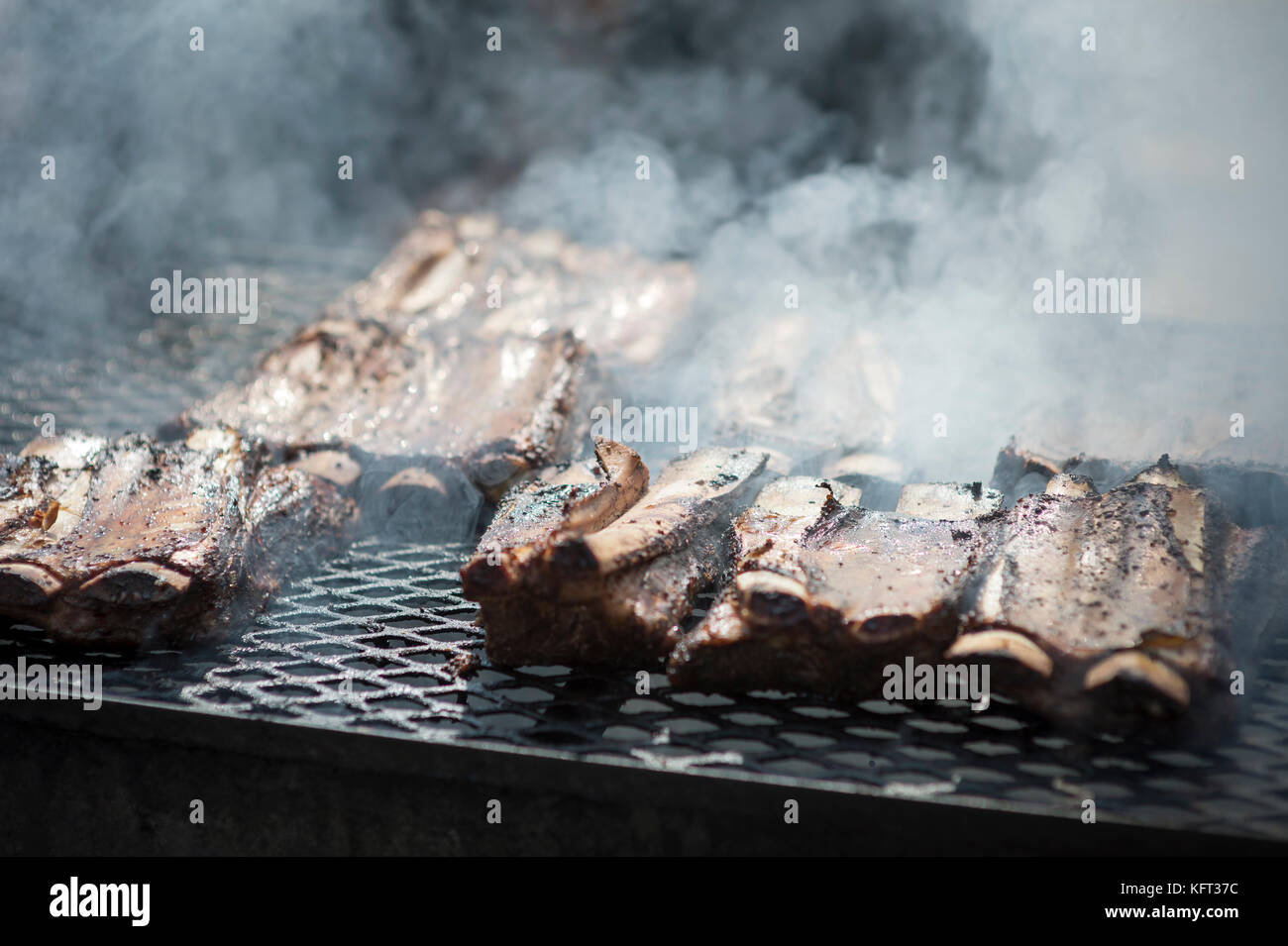 Ribs cooking on a smoky barbecue grill Stock Photo Alamy