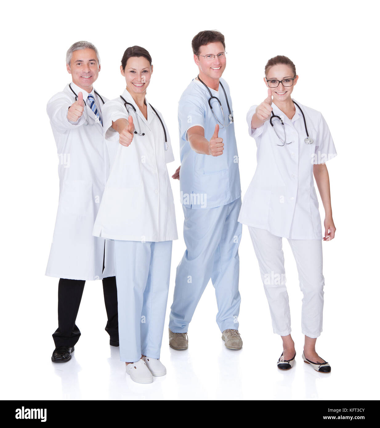 Group of four medical professionals with a male doctor and surgeon and two females doctors on a white studio background Stock Photo