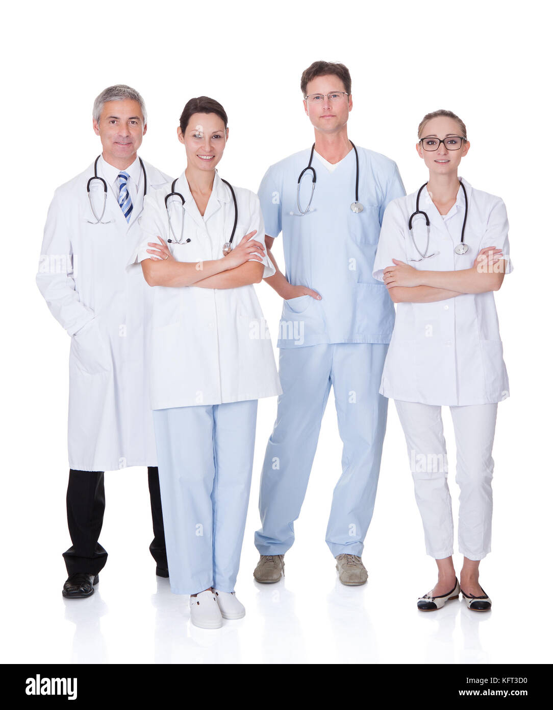 Group of four medical professionals with a male doctor and surgeon and two females doctors on a white studio background Stock Photo