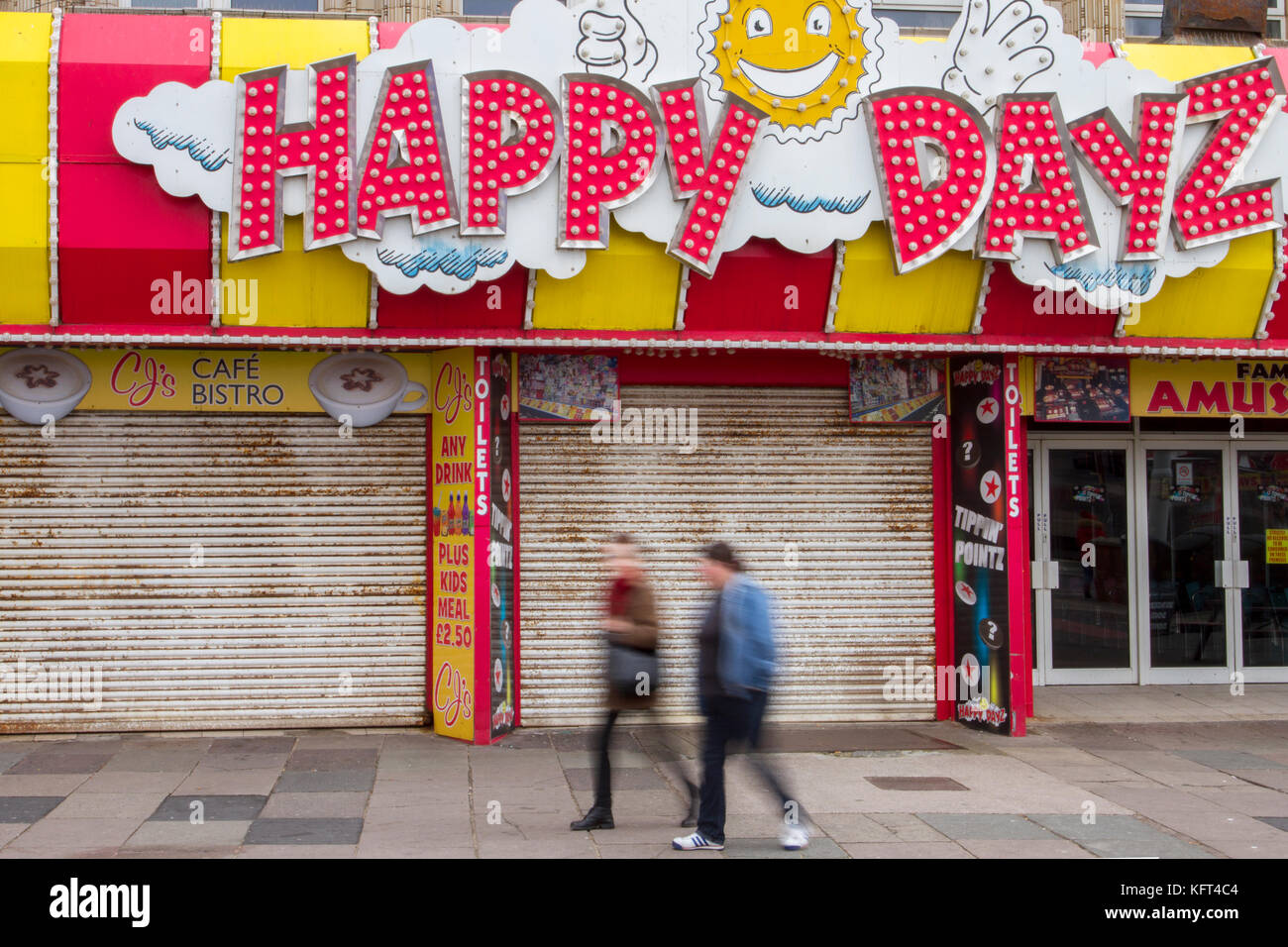 Shop shutters; Out of focus figures passing Retail units To Let, Closed, Closing down, Shuttered shops, businesses in decline, with poor retail sales.   The Malaise affecting British Seaside resorts. Blackpool, Lancashire, UK Stock Photo