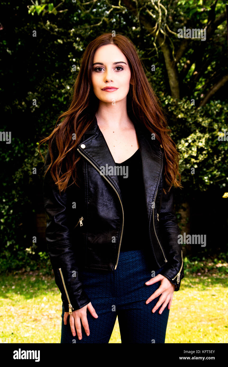 Young lady standing in the garden wearing a leather jacket Stock Photo