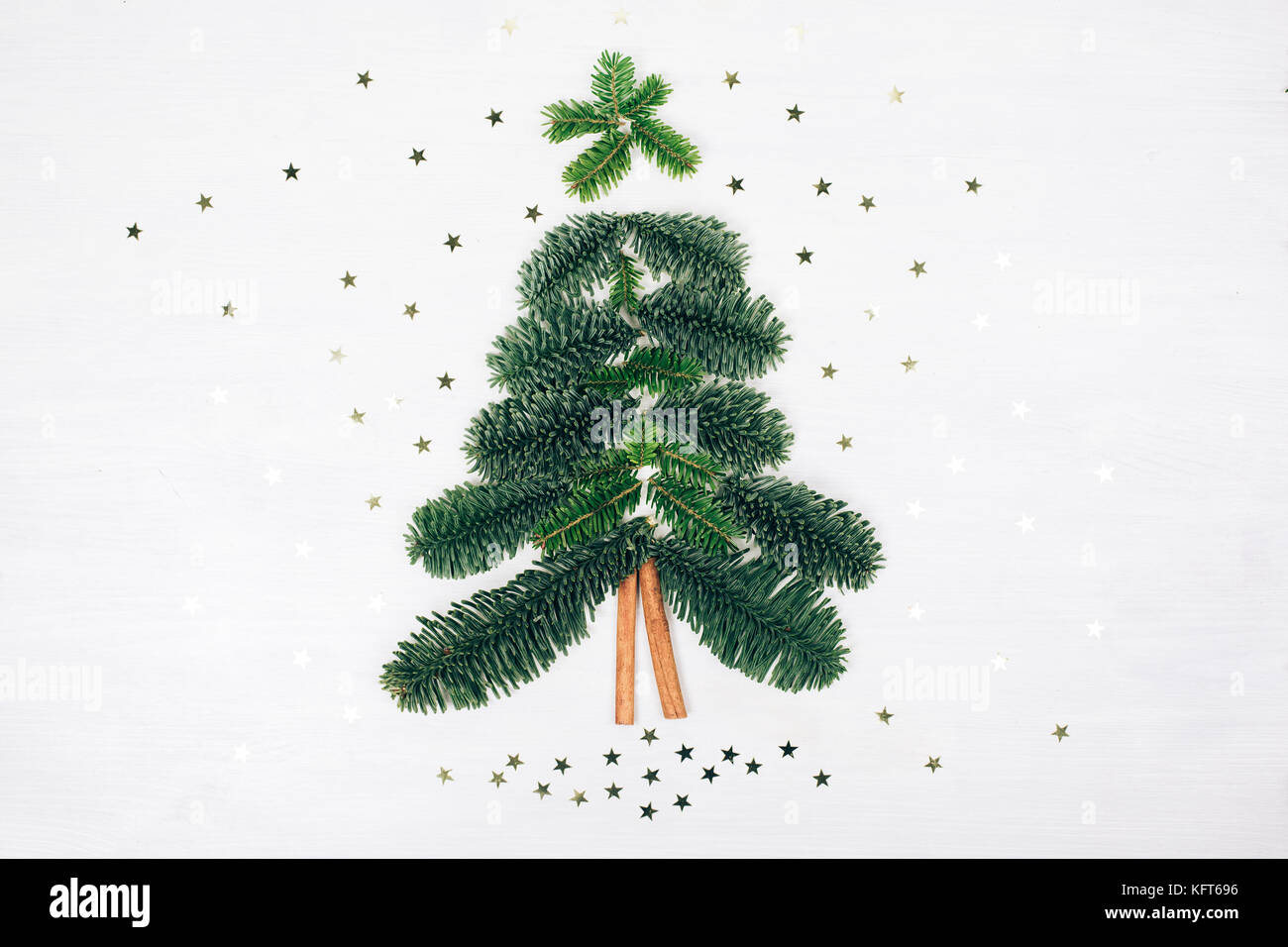 Christmas tree made of fir branches and cinnamon sticks. White wooden ...