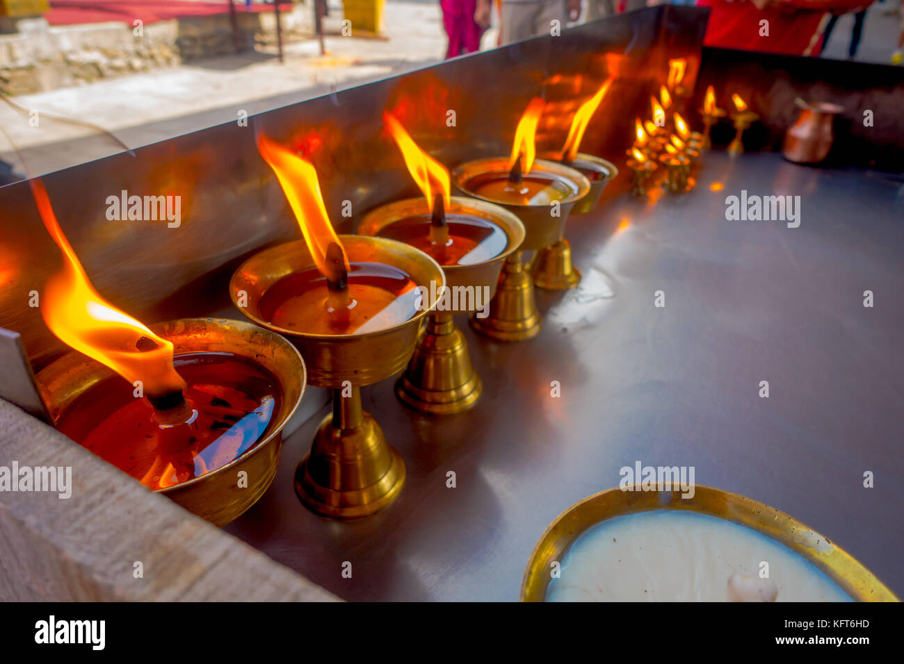 Close up of burning candles inside golden goblets in a temple. Kathmandu, Nepal, Asia Stock Photo