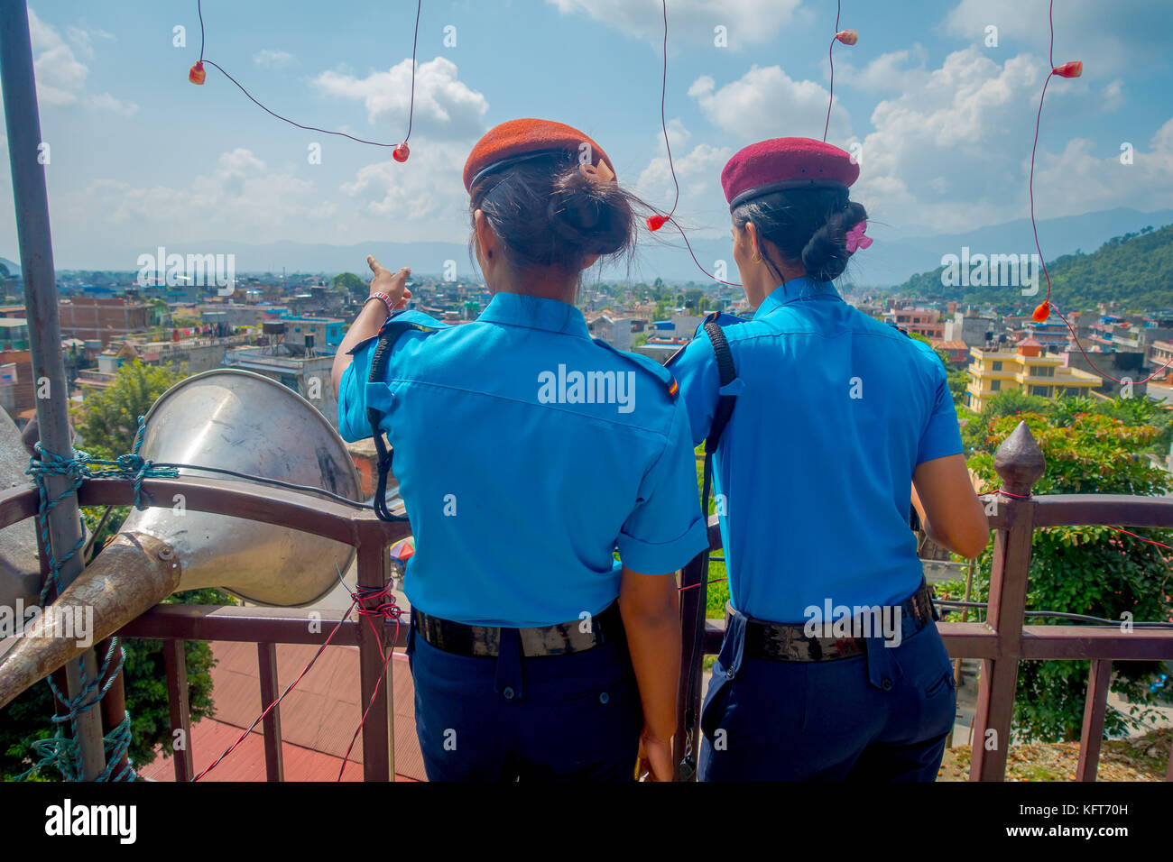 KATHMANDU, NEPAL - SEPTEMBER 04, 2017: Portrait of two women guards giving a back to the camera, from the Nepalese Army posing for camera at the enter of Bindabasini temple in a nature background Stock Photo